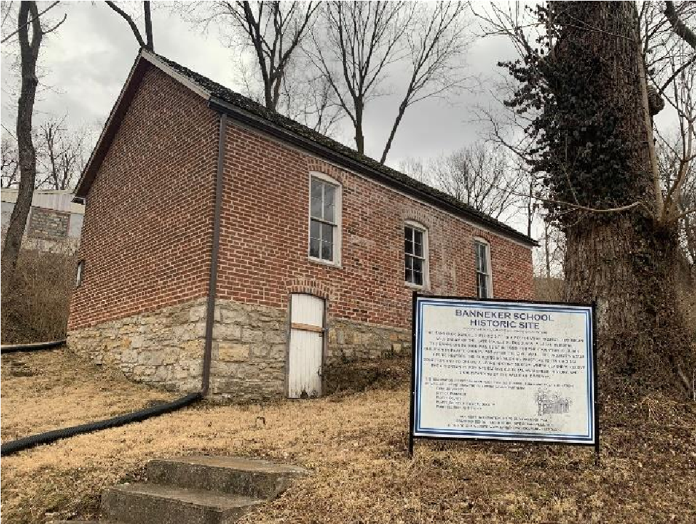 Brick building with stairs in front. A sign for "Banneker School Historic Site" in front.
