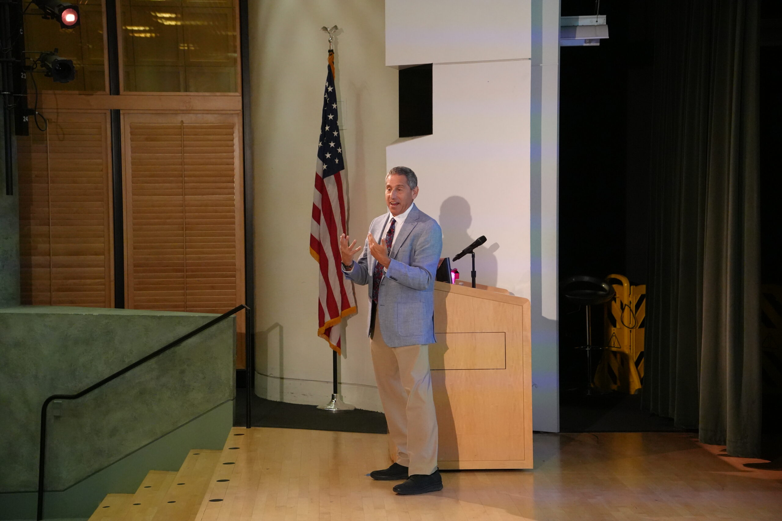 Man stands on stage by podium