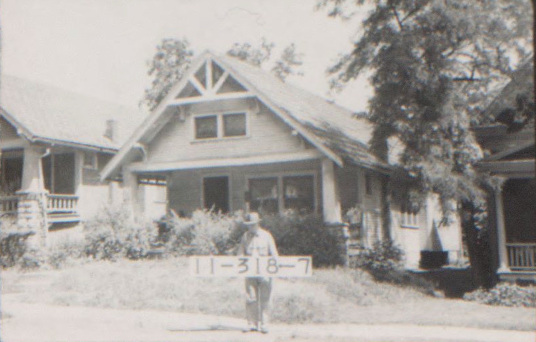 A house on Steptoe street from 1940. One and a half stories with a triangle roof and a man with a tax assessment sign in front.